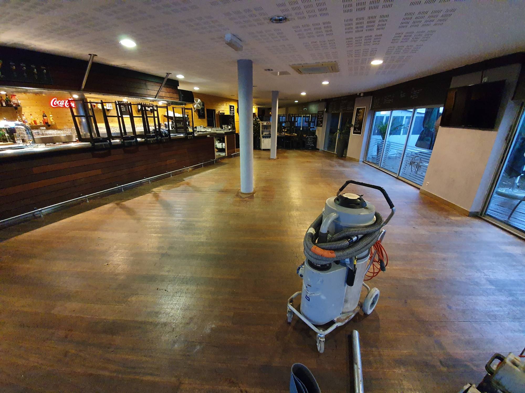 Rénovation et ponçage d'un vieux parquet abimé de restaurant à Bordeaux.