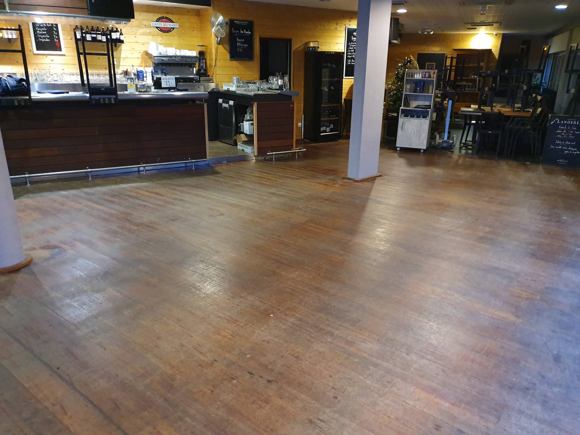 Rénovation et ponçage d'un vieux parquet abimé de restaurant à Bordeaux.