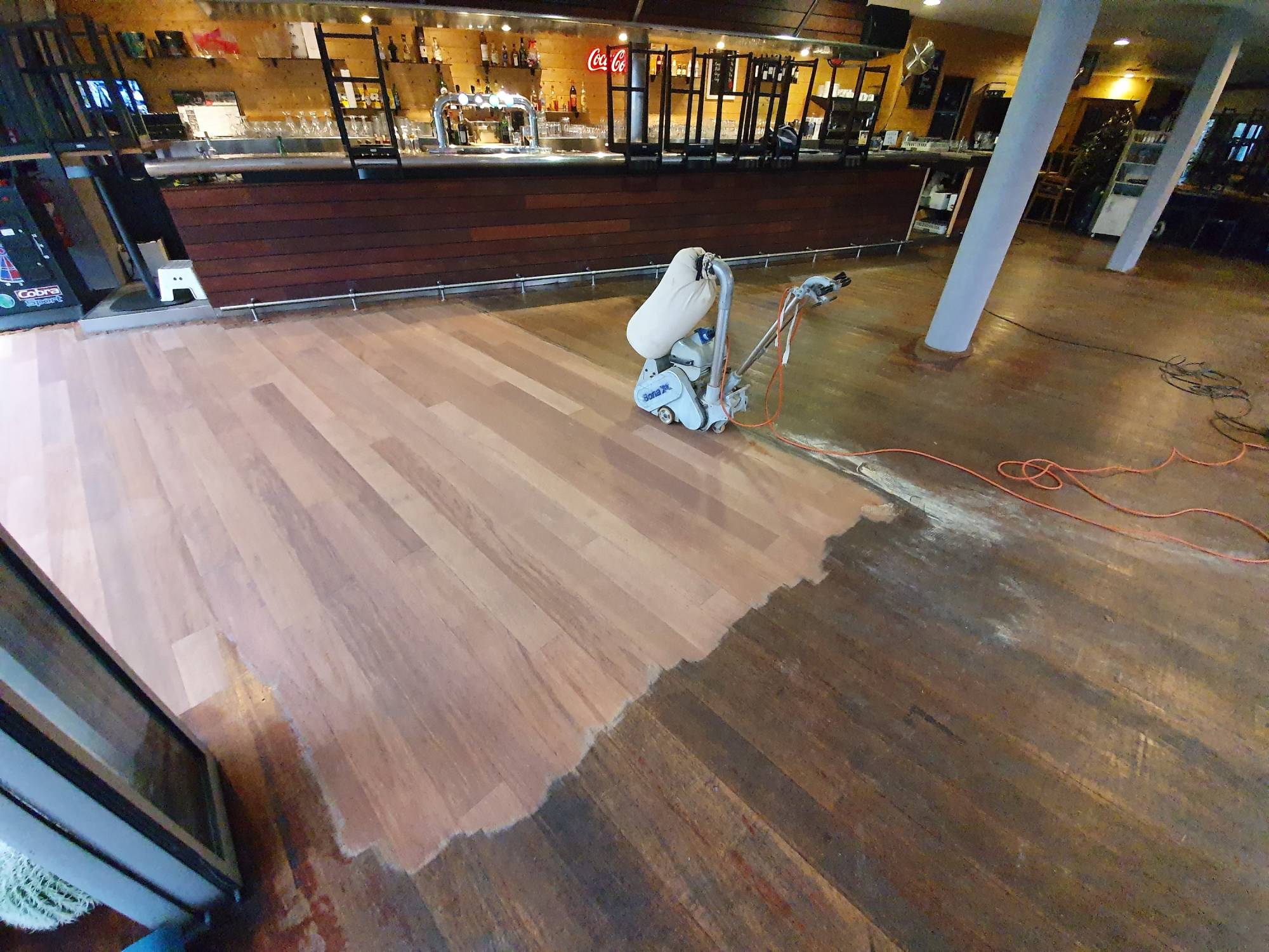 Rénovation et ponçage d'un vieux parquet abimé de restaurant à Bordeaux.