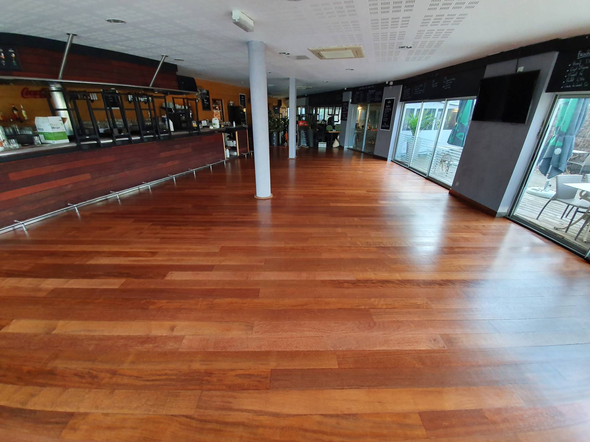 Rénovation et ponçage d'un vieux parquet abimé de restaurant à Bordeaux.