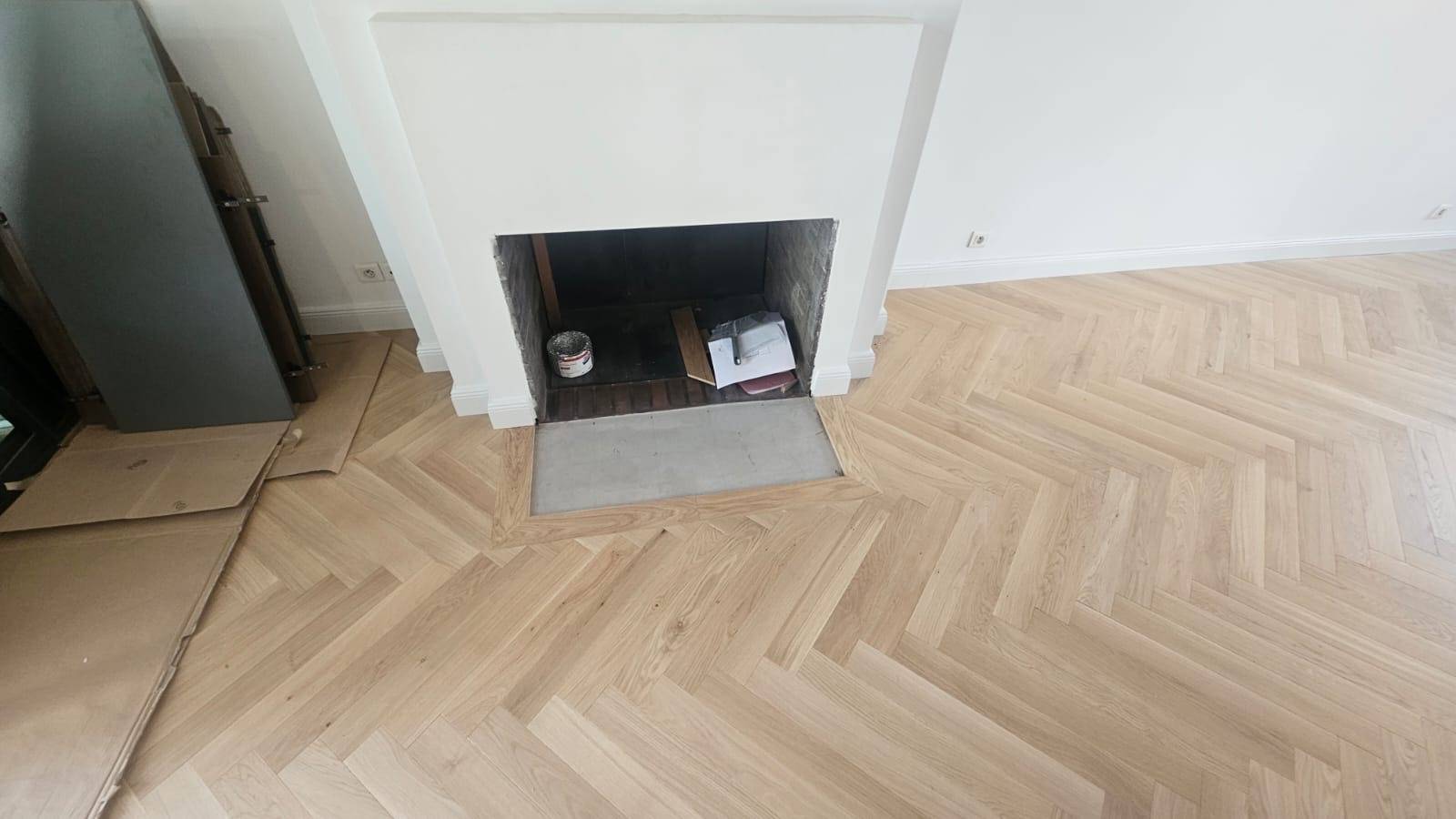 Artisan parqueteur à Bordeaux posant un parquet massif en bâton rompu sur chape.