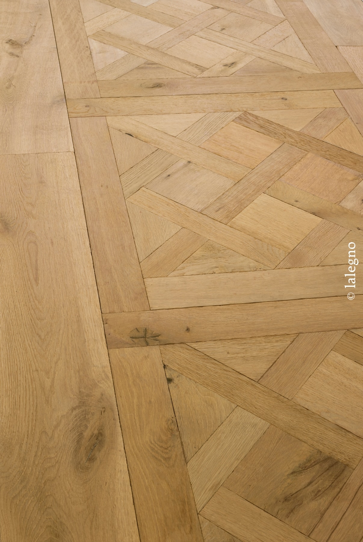 Parquet chêne rustique: motif géométrique complexe avec bordure de larges lames. Tonalité dorée naturelle. © lalegno.