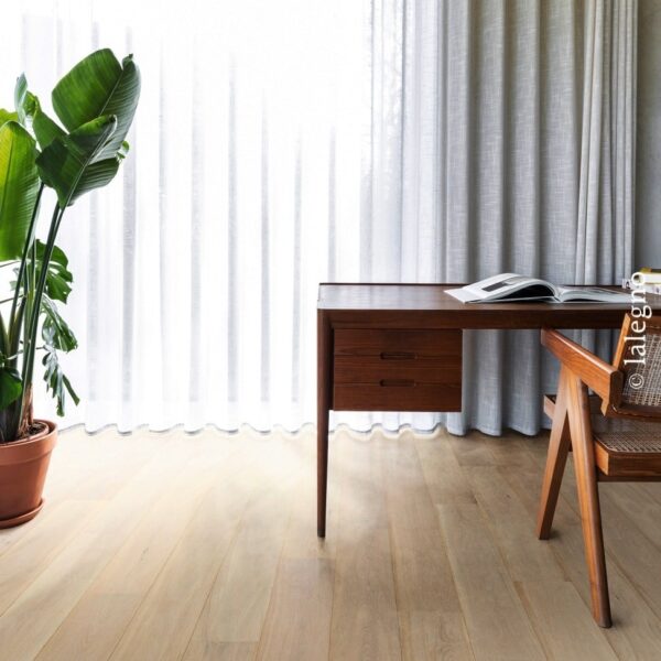 Parquet chêne clair, bureau moderne bois foncé, chaise cannage devant des rideaux vaporeux. Plafond brut en planches de bois.