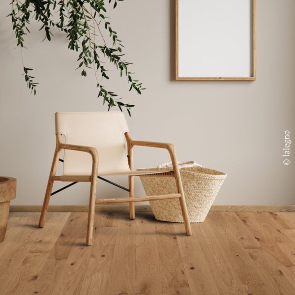 Intérieur moderne avec parquet chêne rustique. Chaise en bois et cuir beige, panier tressé. Cadre photo mural et branches d'olivier. © lalegno.