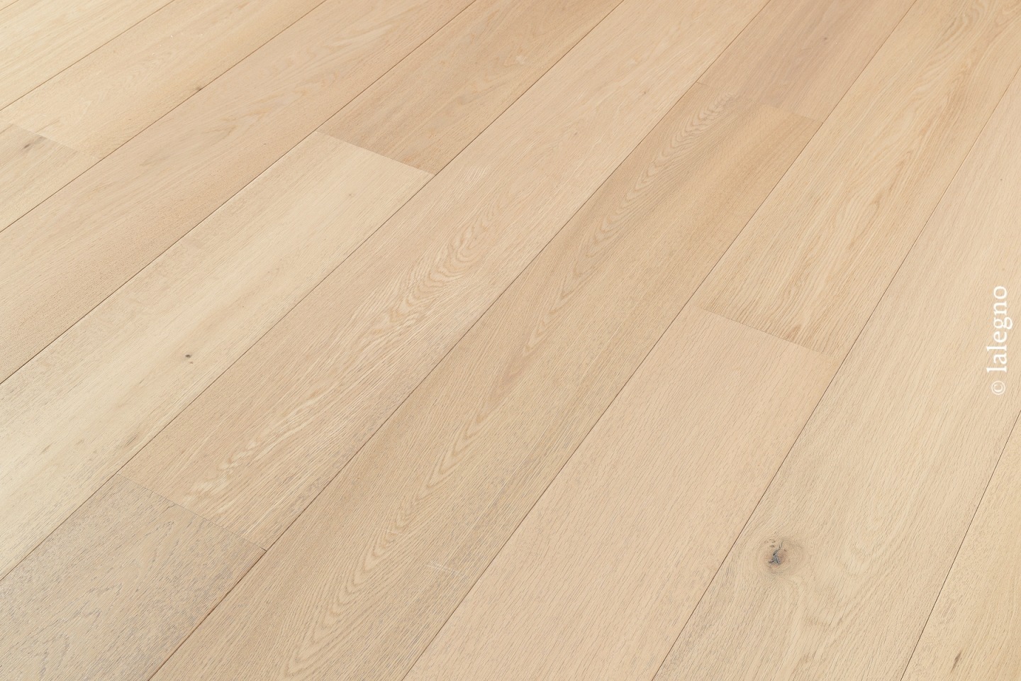 Parquet chêne clair à lames larges, posé en diagonale. Finition bois naturel/blond avec grain visible. Copyright lalegno.