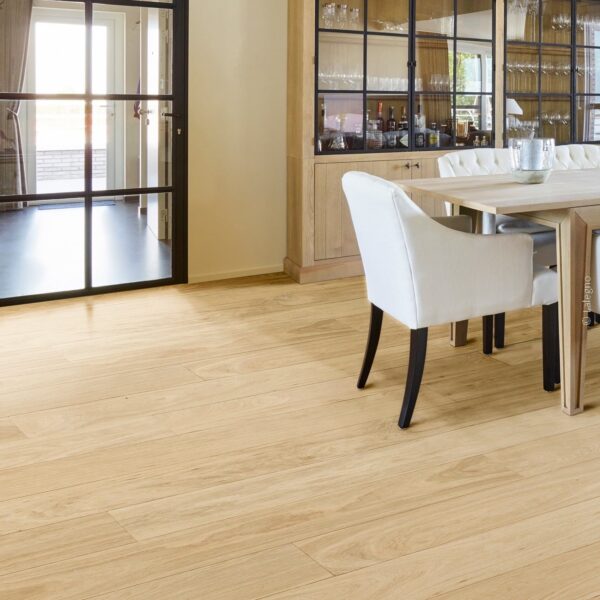 Salle à manger lumineuse : parquet chêne clair, porte vitrée noire industrielle et buffet en bois massif avec vaisselier vitré.