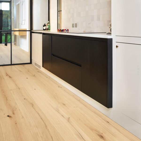 Intérieur moderne : parquet clair, meubles bas cuisine noir et blanc, crédence en marbre, cloison vitrée noire.