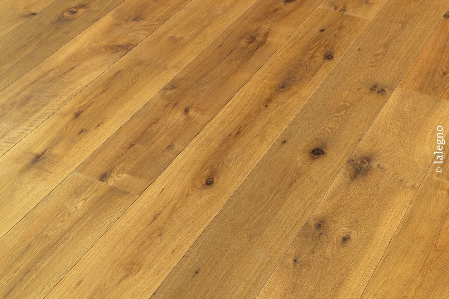 Parquet rustique en chêne doré aux nœuds apparents, posé en diagonale. Lames larges et finition huilée. © lalegno.