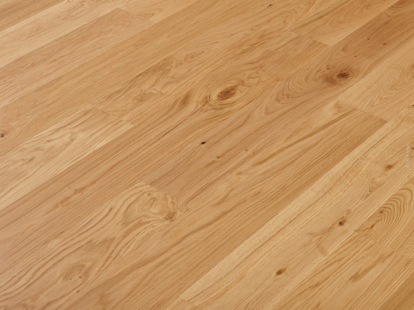 Parquet en chêne clair brossé posé en diagonale. La texture naturelle du bois révèle des nœuds sombres et des veinures chaudes.