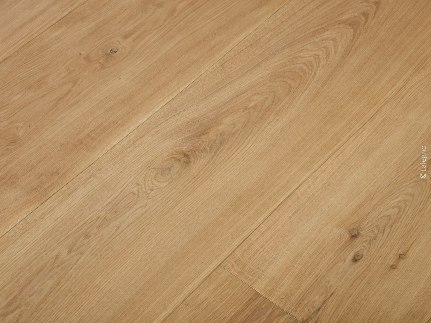 Plancher en bois de chêne naturel, posé en diagonale. Grain riche et nœuds rustiques.