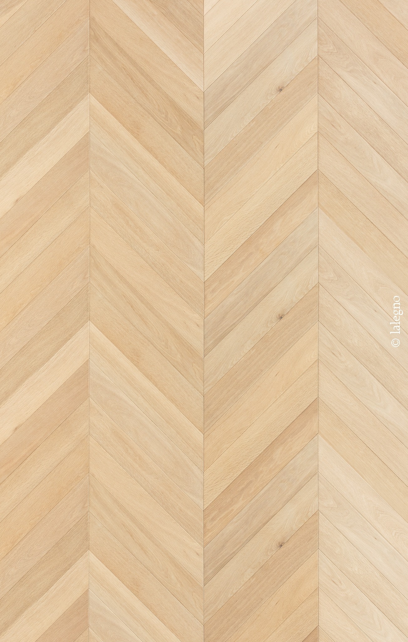 Texture de parquet en bois clair posé en chevron. Les lames forment des V pointus. Grain naturel et inscription .