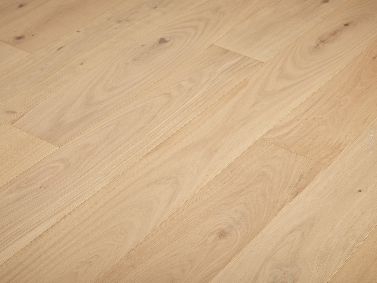 Plancher en bois de chêne clair, lames larges posées en diagonale, grain naturel et petits nœuds visibles.