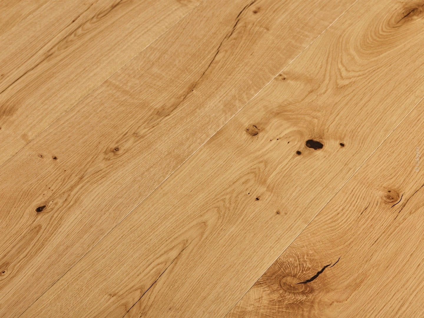 Plancher en bois de chêne clair, gros plan en diagonale. Lames rustiques avec de nombreux nœuds foncés, fentes et grain prononcé.