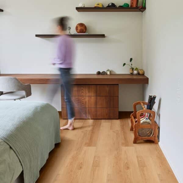 Plancher à l'aspect bois clair dans une chambre moderne avec lit, bureau flottant en noyer et étagères sportives.