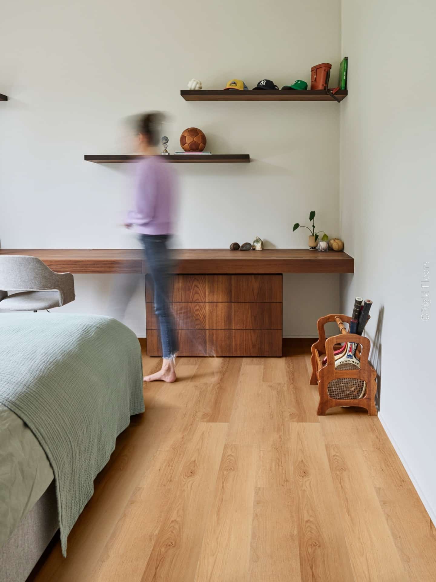 Plancher bois clair dans une chambre moderne. Bureau et étagères murales en noyer foncé. Décoration sportive et minimaliste.