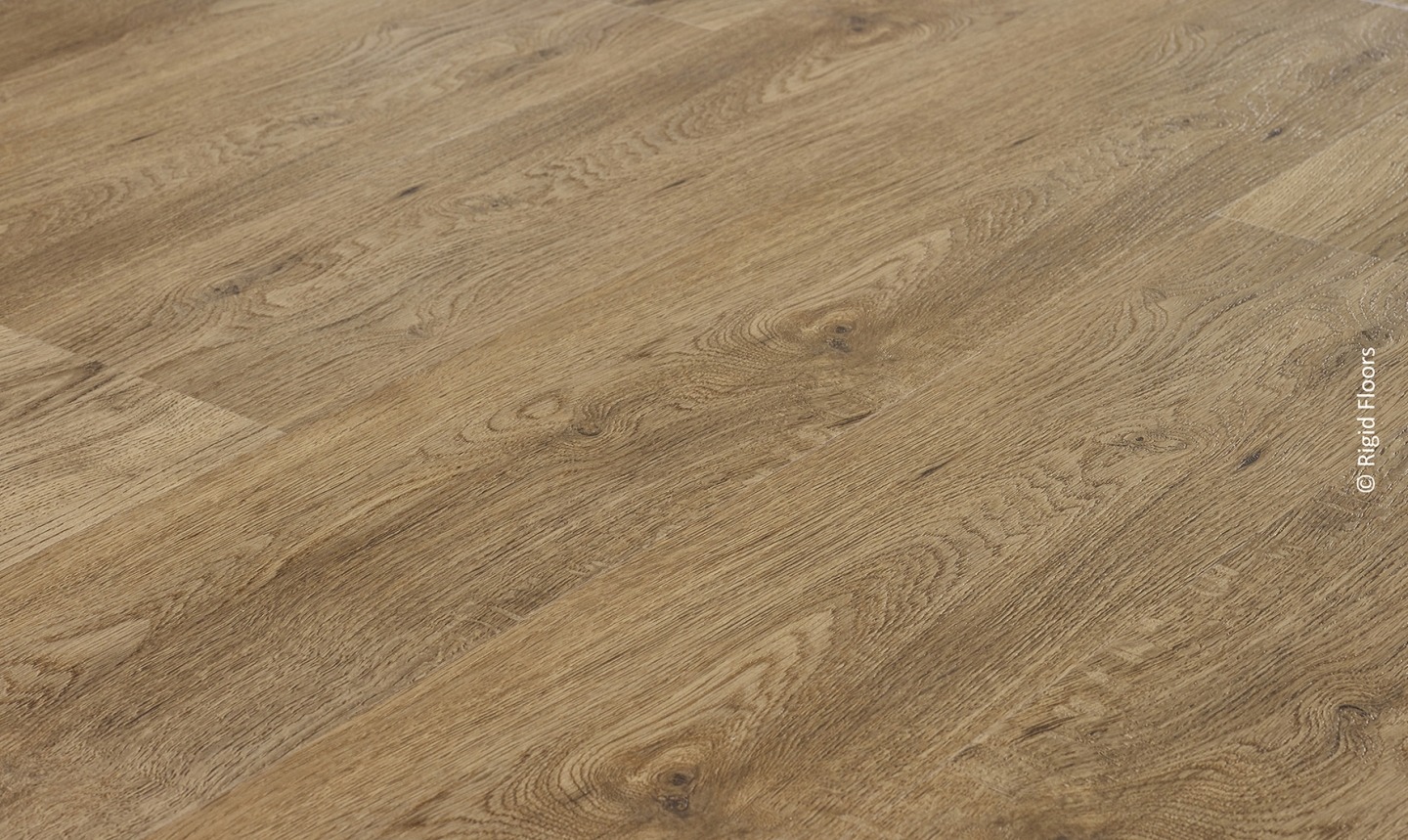 Plancher vinyle rigide aspect bois chêne brun clair, texture grain de bois réaliste. Pose en angle. © Rigid Floors.