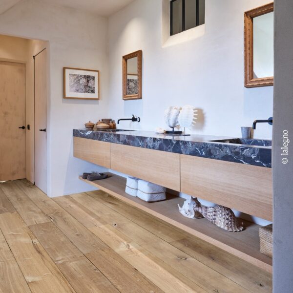 Double vasque flottante bois chêne clair et marbre noir dans une salle de bain rustique chic. Plancher bois à larges lames.