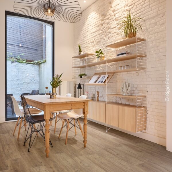 Salle à manger moderne: sol rigide imitation bois, mur de briques blanches, table rustique et étagères String. Crédit: Rigid Floors.