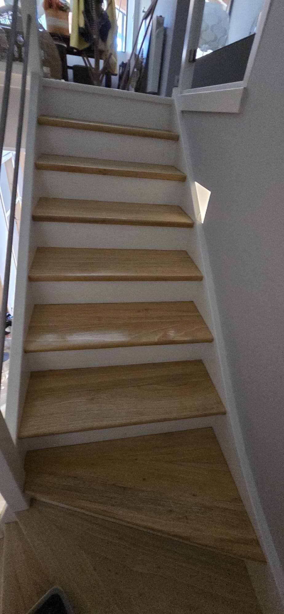 Escalier intérieur moderne avec marches en bois clair et contremarches blanches, style épuré et lumineux.