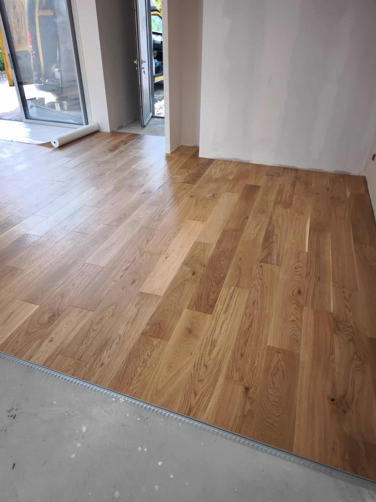 Parquet en chêne massif clair posé dans une pièce lumineuse en rénovation.
